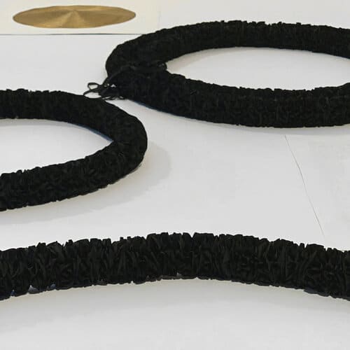  Anne Wilson, Absorb/Reflect , 2020Mourning Garlands nos. 1, 2, 3... (ribbon, thread). Golden Roundels nos. 1, 2 (damask table napkin, ink, gold thread embroidery). Installation on floor platform, 132 x 64 inches. Photo: Anne Wilson Studio 